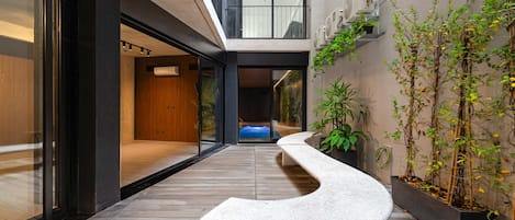 Un intérieur moderne avec un banc incurvé, un plancher en bois et une vue sur une piscine.