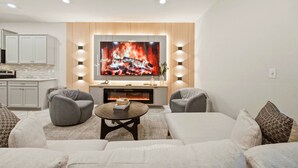 Ein modernes Wohnzimmer mit Fernseher, Kamin und einer gemütlichen Sitzecke.