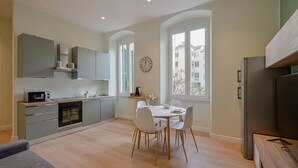 A modern kitchen with a dining area, built-in appliances, and large windows. - GuestHost - Cozy 59mq apartment, perfect for 4 people, located on the first floor of a building without a lift (stairs to access it).The property is located in a well-served residential neighborhood, adjacent to the Historic Center.The Central Station, r (La Spezia)