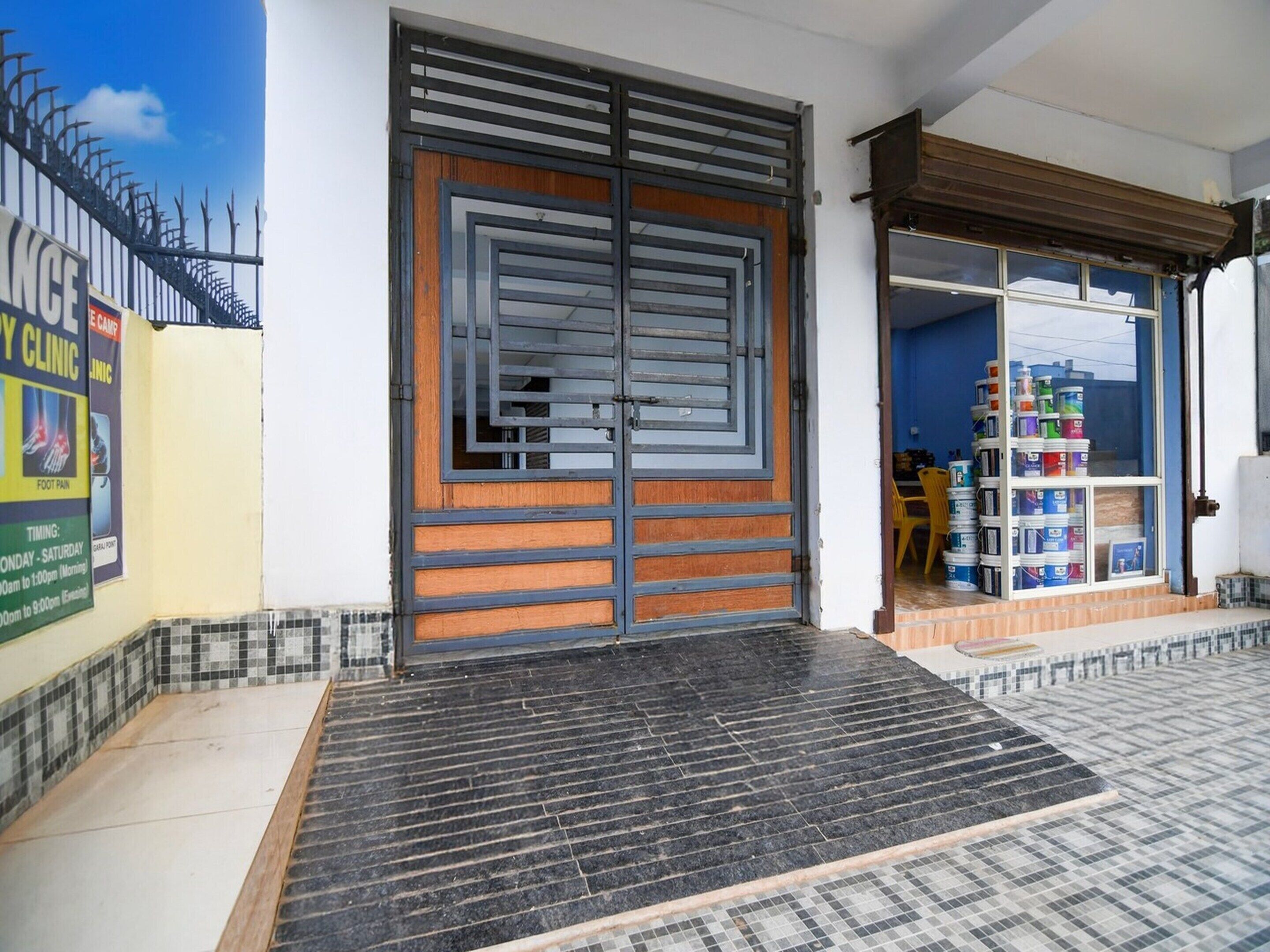 A clinic with a large wooden door and a tiled entrance.
