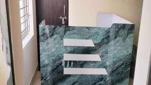 Un mostrador de recepción con encimera de mármol y tres letreros horizontales blancos.