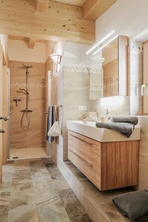 Un bagno moderno con doccia, lavabo e specchio.