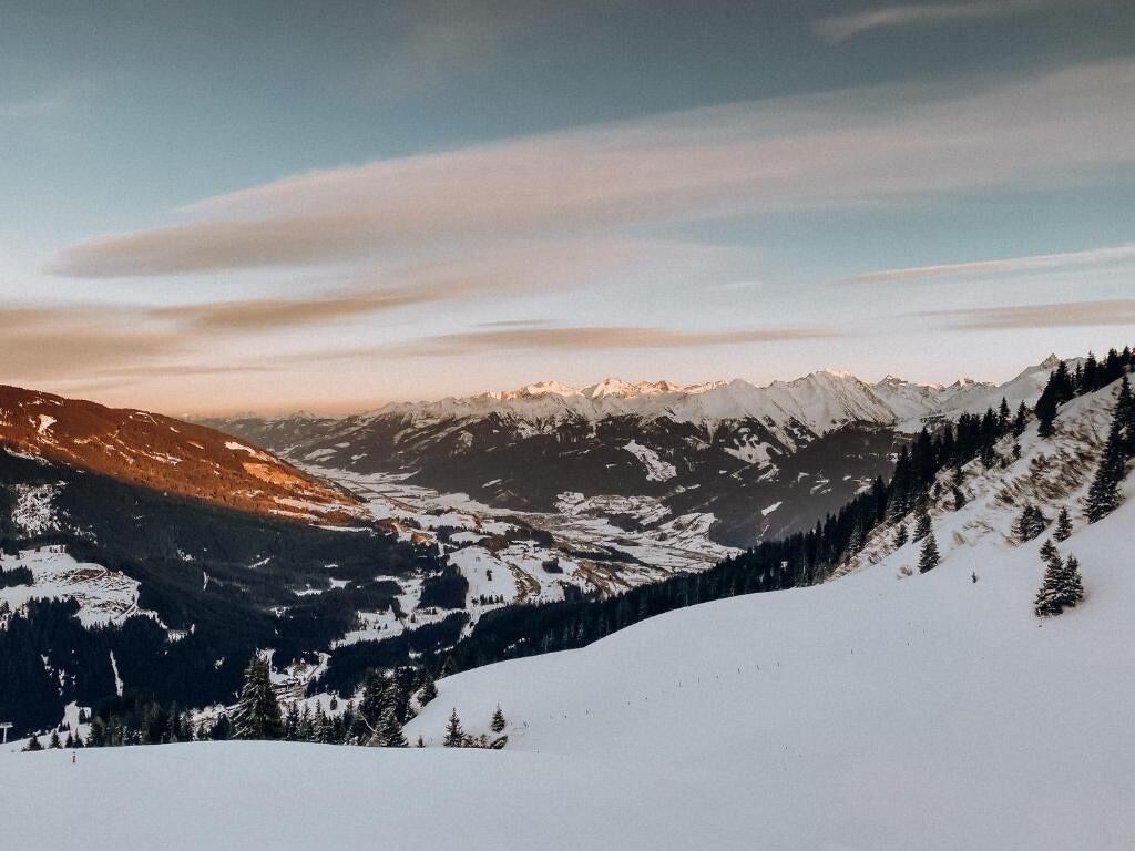 Un paysage de montagne enneigé, sous un ciel dégagé.