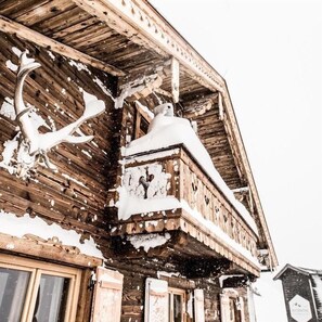 Un edificio di legno con esterno innevato e un balcone.