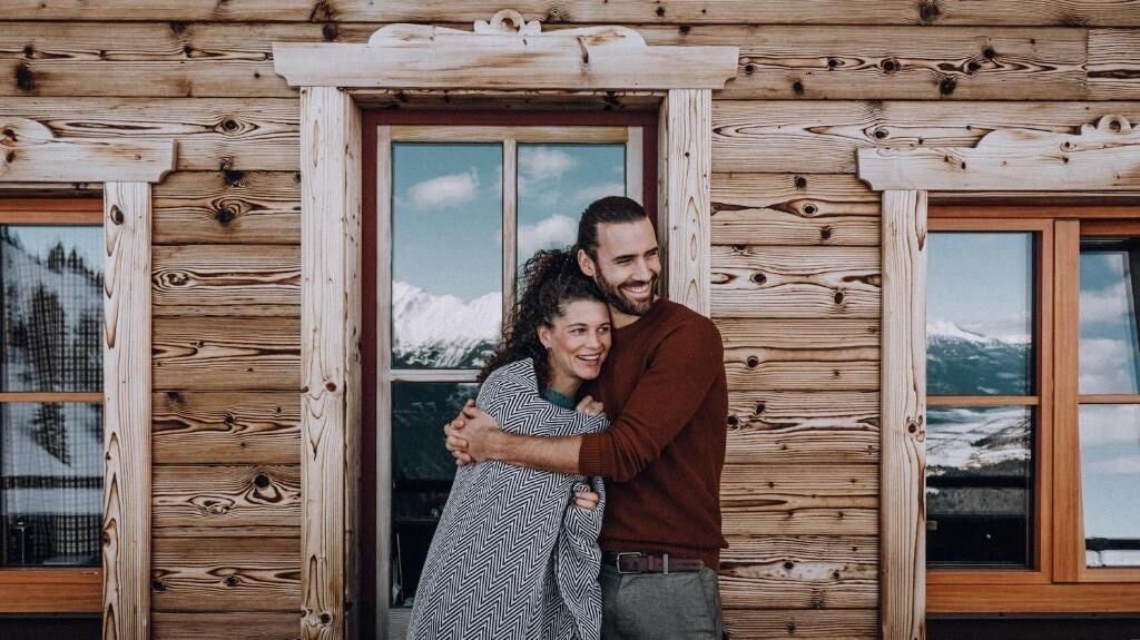 Une cabane en bois avec une grande fenêtre et une porte.