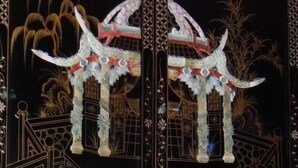 A traditional Chinese gate with intricate designs and a symmetrical structure. - Oriental Suite (Swansea)
