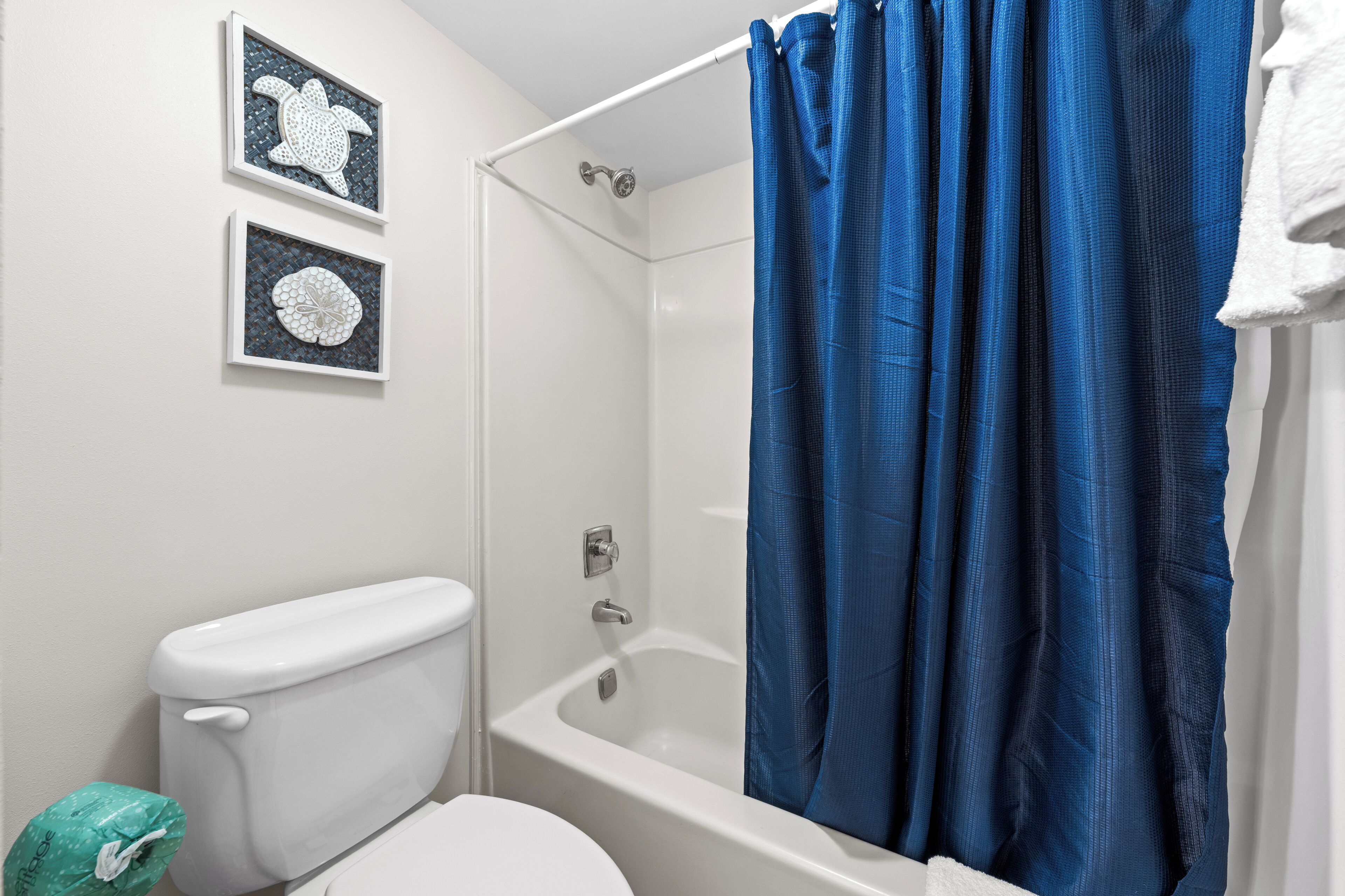 Un baño con inodoro, bañera y cortina de ducha.