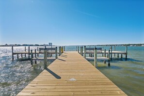 A wooden pier extending into calm waters with clear skies. - Compass Point 510 (Gulf Shores)