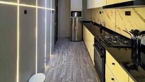 Et moderne køkken med et rustfrit stål køleskab, en gas komfur og en mikroovn.