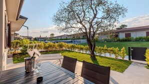 A patio with a table, chairs, a wine bottle, and a glass. - Aurora Lights Suite (Desenzano del Garda)