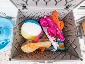 A storage bin filled with various items including a beach ball, a pink umbrella, and a yellow beach ball. - Forever Lane Retreat…
A Family Friendly Pool home in Sarasota (Sarasota)