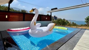 A swimming pool with a swan inflatable, a pink and white inflatable, and a green inflatable. - Hotel Xperience (Ghazir)