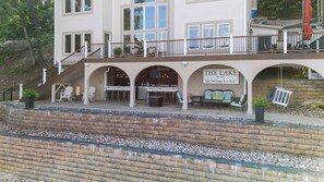 A two-story building with a covered outdoor seating area, a staircase, and a sign that reads 'THE LAKE EST 2005.' - Mimosa Mornings Home for 12 (Eldon)
