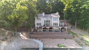 Une grande maison à deux étages, dotée d’un balcon et d’une terrasse couverte.