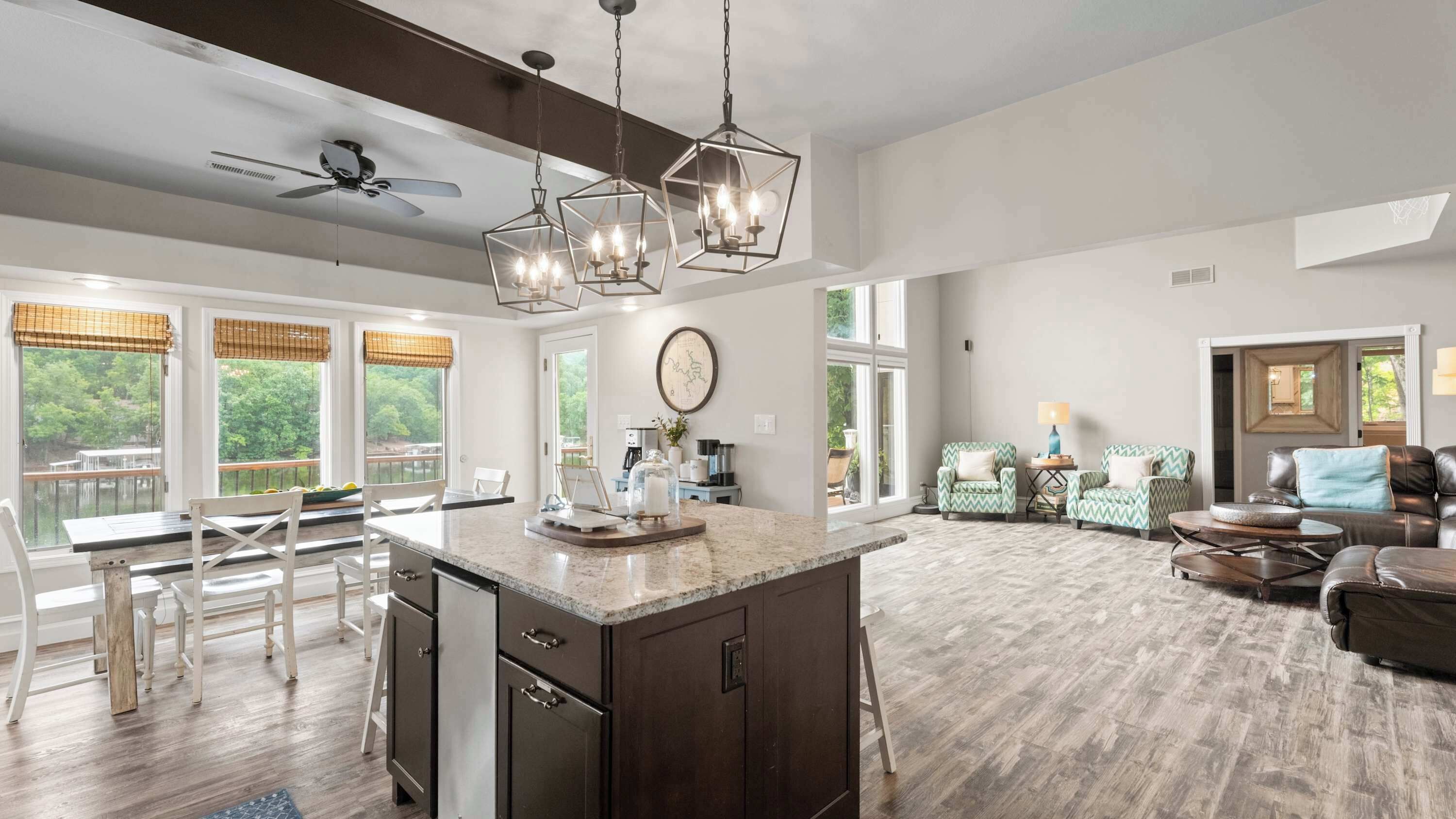 A spacious living area with a large island, dark wood cabinets, and a ceiling fan.