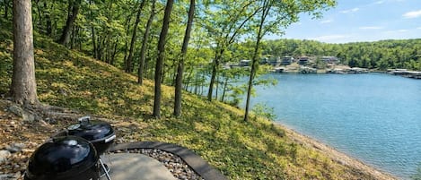 Un sendero junto al lago con una parrilla y un camino pavimentado.
