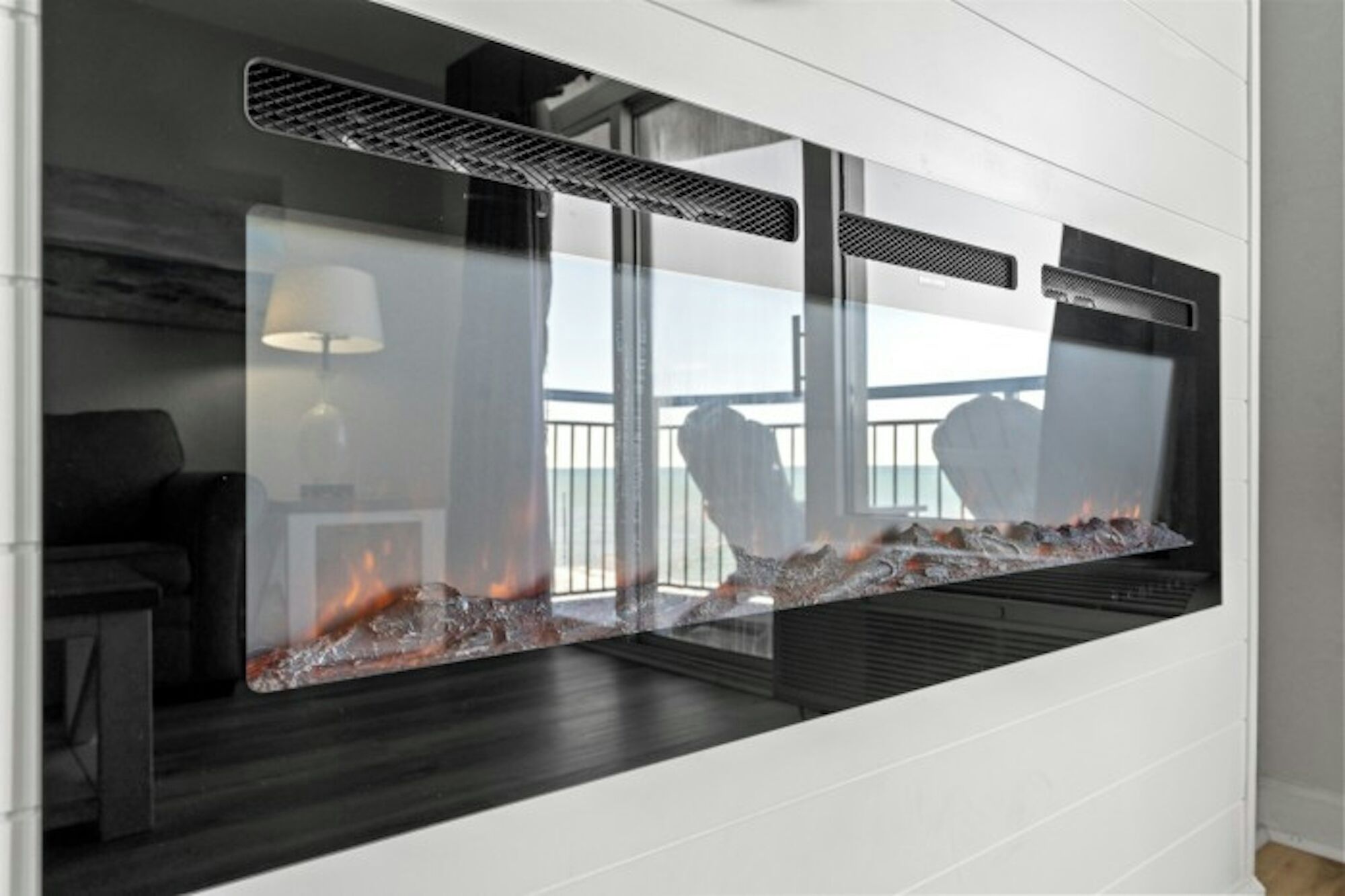 A modern interior with a glass partition, a fireplace, and a view of the outdoors.