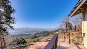 Ein Balkon mit Blick auf eine gebirgige Landschaft.