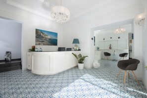 Eine moderne Küche mit weißer Arbeitsplatte, einem Topf mit Pflanze und einem Essbereich mit zwei Stühlen.