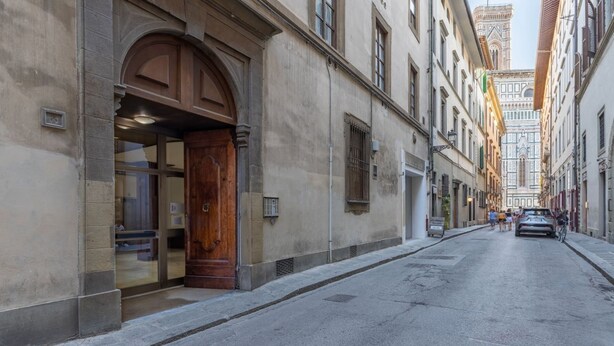 Straßenansicht mit einem Gebäude, das eine große Holztür und Fenster zeigt.
