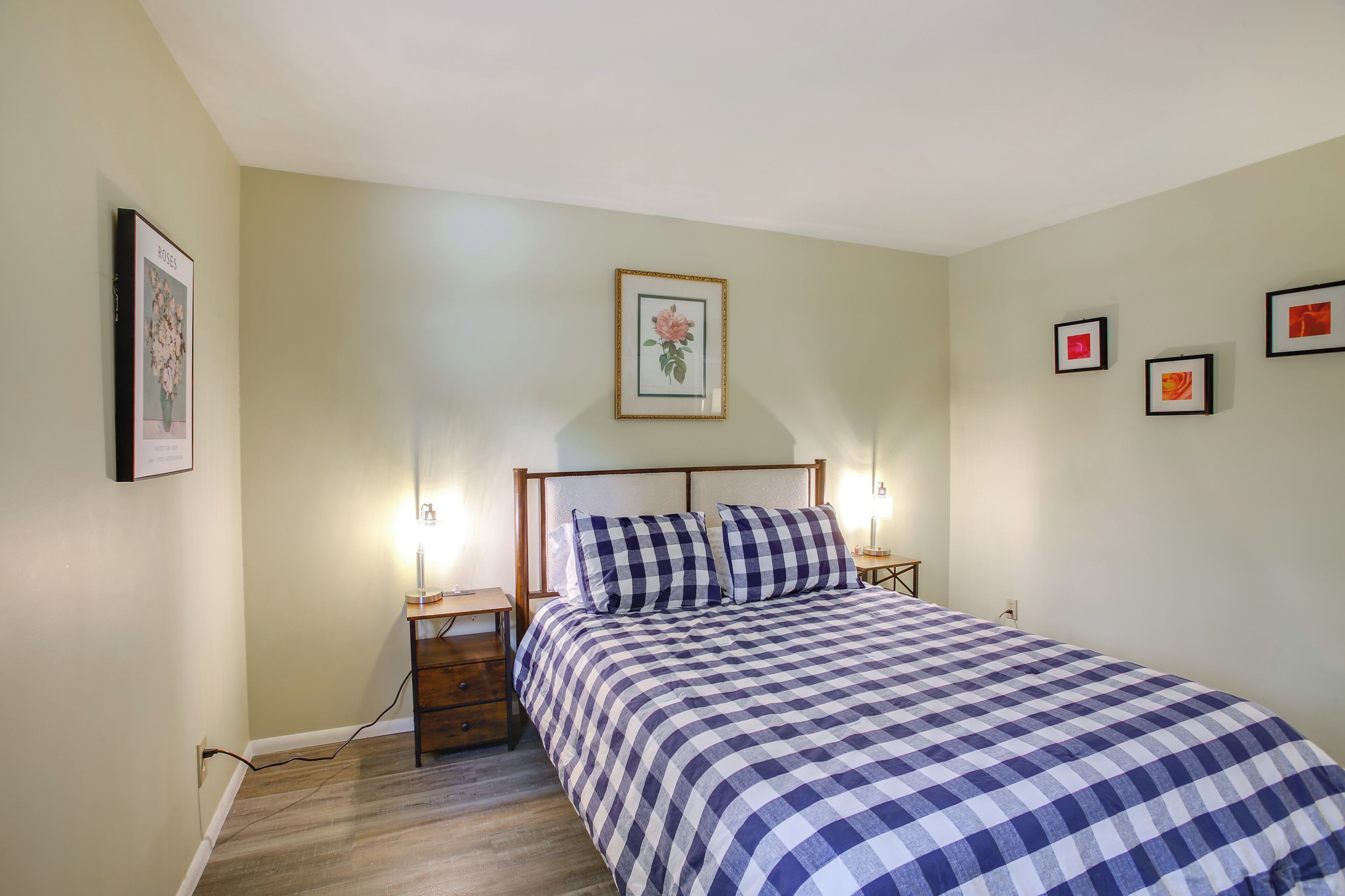 Un dormitorio con cama, mesitas de noche y lámparas de pared.