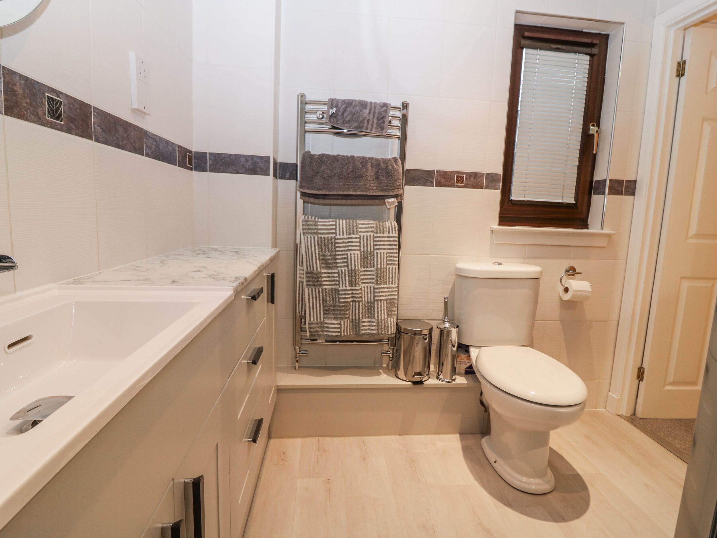 Een badkamer met een bad, toilet en een handdoekhouder.