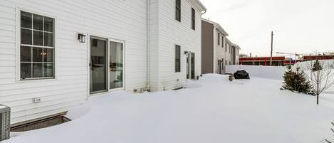 Un edificio residencial blanco con un porche cubierto y un garaje.