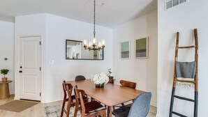 A dining area with a wooden table, chairs, a chandelier, and a ladder against the wall. - Half-mi to the Triangle! Chic Emmaus Townhome (Emmaus)