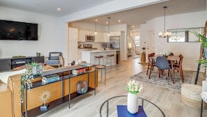 A modern living room with a dining area, kitchen, and a staircase leading to another level. - Half-mi to the Triangle! Chic Emmaus Townhome (Emmaus)