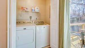 A laundry area with two washing machines and a shelf with detergent bottles. - < 1 Mi to Msu! Updated Springfield House w/ Deck (Springfield)