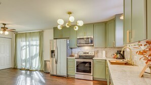 A kitchen with green cabinets, a stainless steel refrigerator, a microwave, an oven, and a sink. - < 1 Mi to Msu! Updated Springfield House w/ Deck (Springfield)
