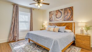 A bedroom with a bed, a ceiling fan, a nightstand, a lamp, and artwork on the wall. - < 1 Mi to Msu! Updated Springfield House w/ Deck (Springfield)