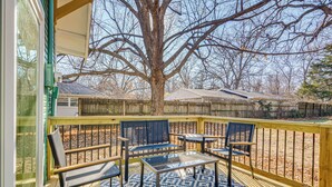 A deck with a glass table and chairs, a patterned rug, and a view of a tree and a wooden fence. - < 1 Mi to Msu! Updated Springfield House w/ Deck (Springfield)