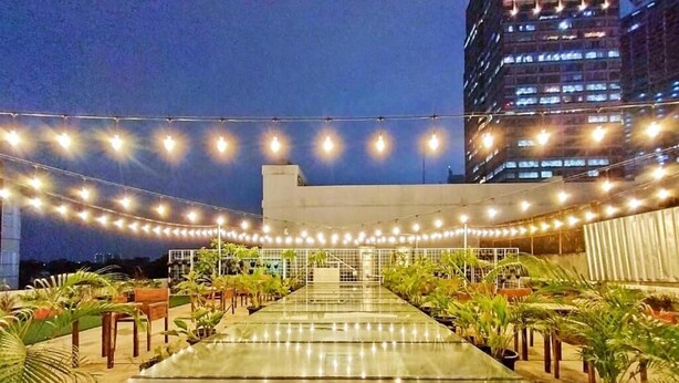 An outdoor terrace with string lights, potted plants, and a glass table. - Dafam Enkadeli Thamrin Jakarta (Jakarta)