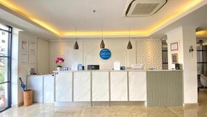 A hotel reception area with a marble counter, pendant lighting, and a sign indicating the hotel name. - Dafam Enkadeli Thamrin Jakarta (Jakarta)