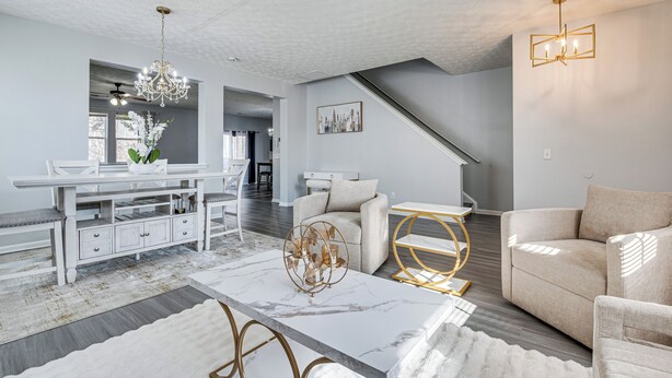 A spacious living room with a marble coffee table, a chandelier, and a sofa. - Great for Gatherings! Elegant Atlanta Retreat (Atlanta)