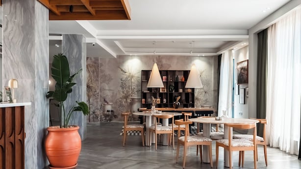 A modern dining area with marble walls, wooden furniture, and pendant lighting. - Boutique Nest Luxury 2BR Serviced Apartment (Cairo Governorate)
