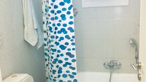 A bathroom with a toilet, a bathtub, and a shower curtain. - Naoussa Apricot Garden, 5' to Center, 5' to Beach (Naousa)