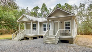 A two-story cabin with a porch and a covered front porch area. - Gulfport Cottage w/ Fire Pit: Relax & Recharge! (Gulfport)