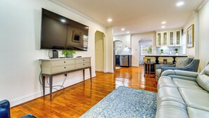 A modern living room with a flat-screen TV, a grey sofa, and a blue rug. - Stay Near Averett & Caesars! Cozy Home w/ Patio (Danville)
