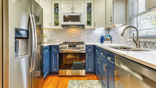 A modern kitchen with stainless steel appliances, blue cabinets, and a patterned backsplash. - Stay Near Averett & Caesars! Cozy Home w/ Patio (Danville)