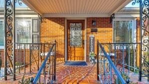 A brick house with a wooden porch, a metal gate, and a welcome sign. - Stay Near Averett & Caesars! Cozy Home w/ Patio (Danville)