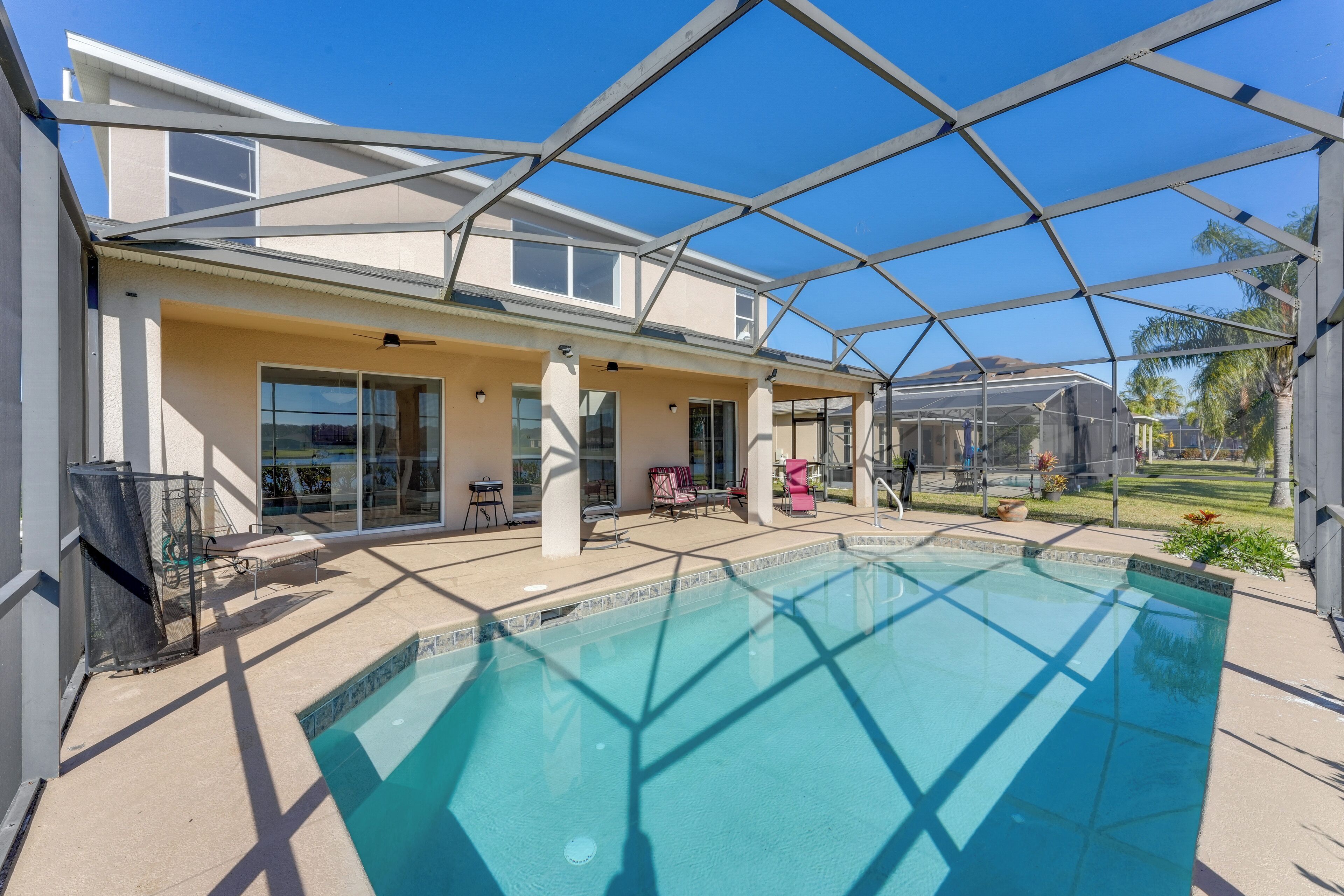A modern house with a swimming pool, covered patio, and large windows.