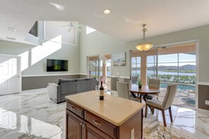 A spacious living area with a kitchen island, a dining table, and a view of a lake. - Fish & Boat Lake Toho: Family Gem Near Theme Parks (Kissimmee)