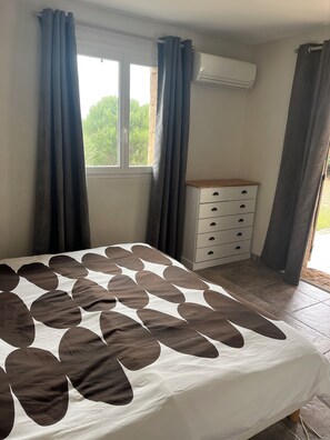 Ein Schlafzimmer mit einem Bett, einem Schminktisch und einer Klimaanlage.