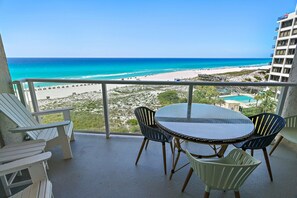 A balcony with a table and chairs, overlooking a beach and ocean. - 🌴Stunning Beachfront Views | Pool | Beachside II #4260🌴 (Miramar Beach)