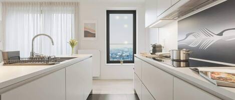 Een moderne keuken met een centraal eiland, een raam met uitzicht over de stad, en een groot schilderij aan de muur.