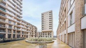 A modern residential building with multiple floors, balconies, and a central courtyard with landscaping. - O’Searys - stylish apartment with stadium view (Oostende)