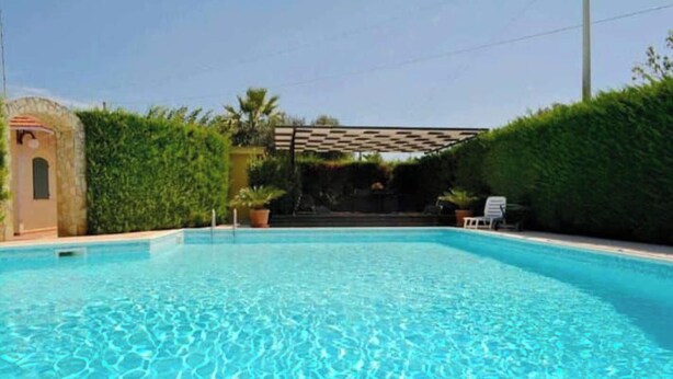 A clear blue swimming pool with a pergola and potted plants. - Villa sole cozy villa located in the countryside cica 3 km from town (SAN VITO DEI NORMANNI)