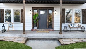 A two-story house with a front porch, a grey door, and a number '1714' on the door. - Gorgeous 6BR Sleeps 16 with Hot Tub, BBQ, Games, Big Screen TV.  Near Downtown (San Antonio)